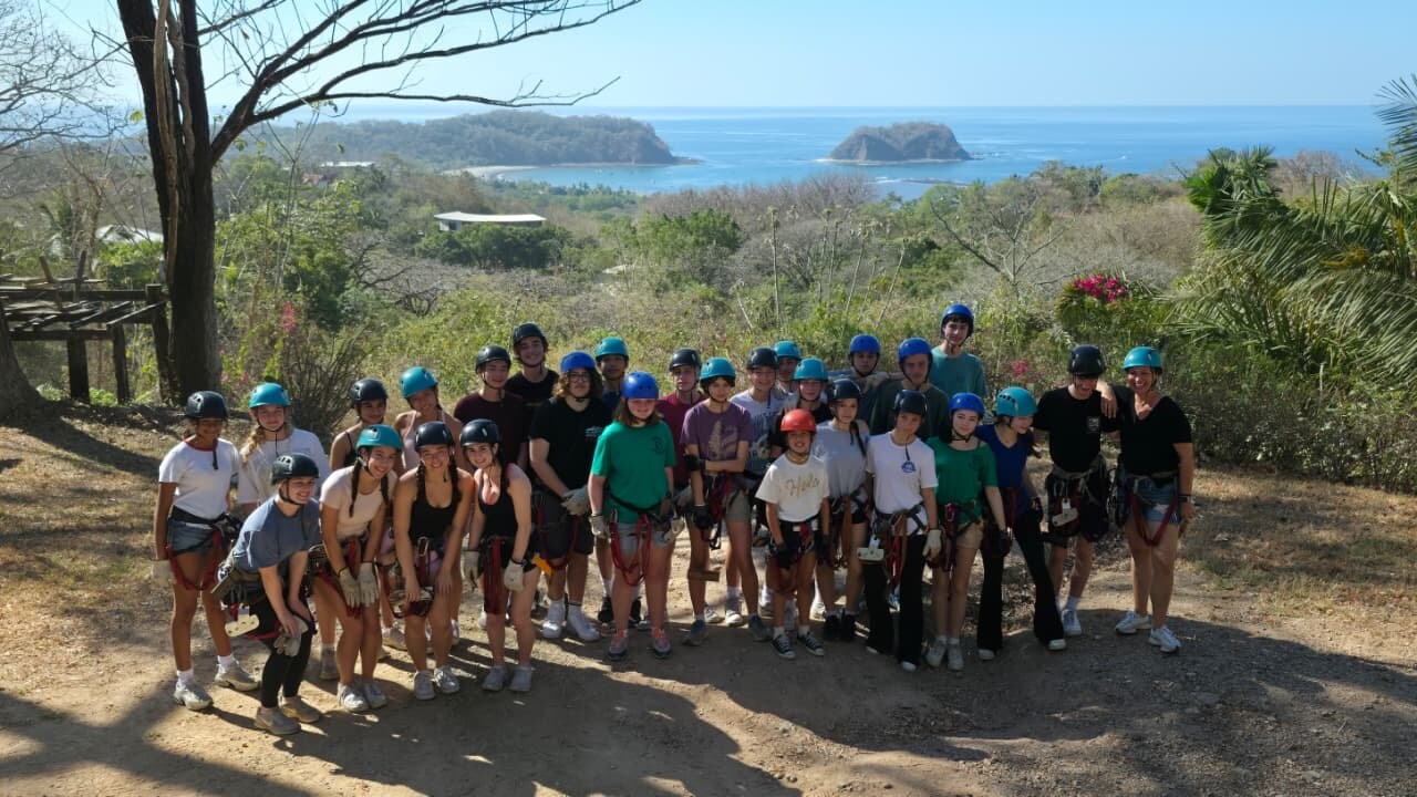Group photo before ziplining, ocean in the background